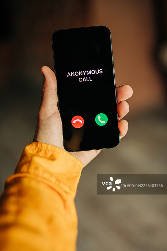 手持智能手机，屏幕上显示匿名来电图片素材