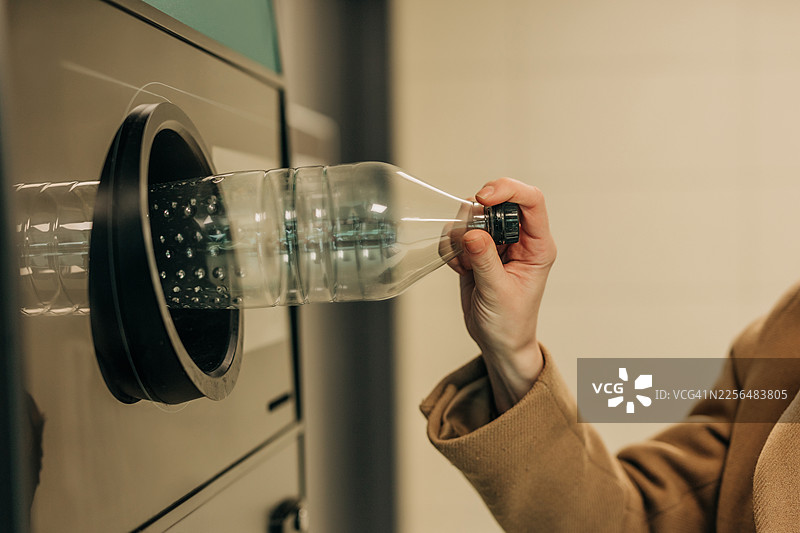 手在自动回收机中回收塑料瓶图片素材
