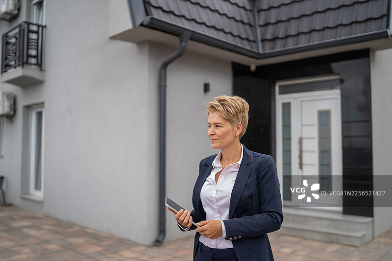 一位女性房地产经纪人在新房前图片素材