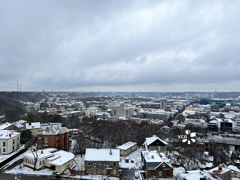 从高处俯瞰被大雪覆盖的城镇，天空呈现出戏剧性的冬日景象，立陶宛考纳斯市图片素材