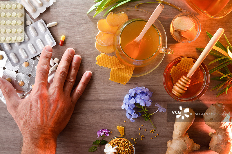 桌上的手，旁边放着用于缓解疼痛的天然疗法和药物图片素材
