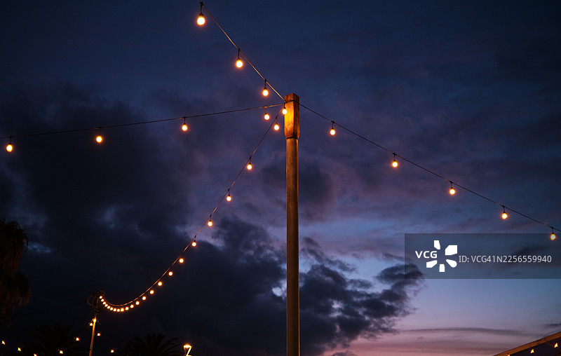 串灯照亮了黄昏的天空，营造出节日气氛图片素材