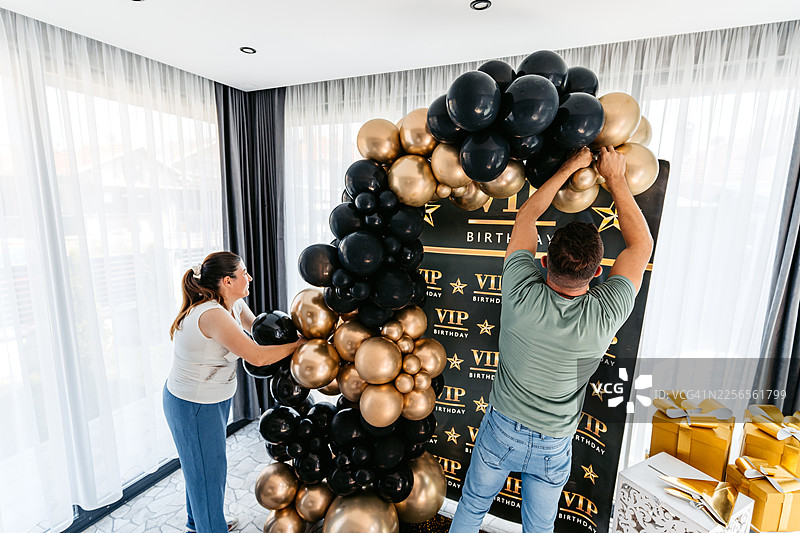 中年男女为生日派对布置气球图片素材