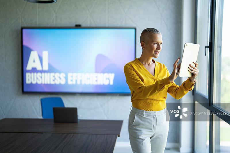 女商人在使用数字平板电脑，屏幕上显示着人工智能商业效率演示图片素材