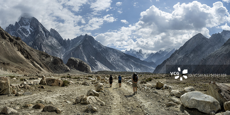 徒步者在巴基斯坦喀喇昆仑山脉的巴尔托罗冰川上徒步，背景是群山。图片素材