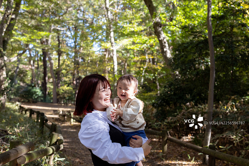 快乐的母亲和她的女儿在森林里图片素材