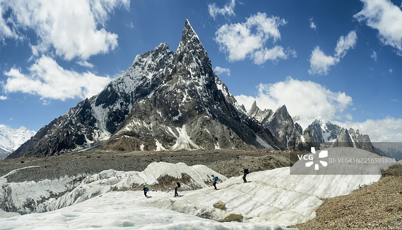 徒步者在巴基斯坦喀喇昆仑山脉的 the Mitre Peak 山下的冰川上徒步图片素材