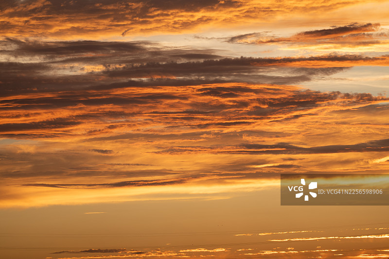 金色日落天空，云彩和宁静的地平线光芒，营造温暖宁静的氛围图片素材