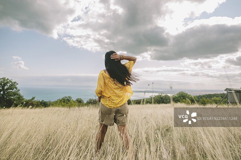 一个人站在高高的草丛中，拥抱自由与宁静的自然图片素材
