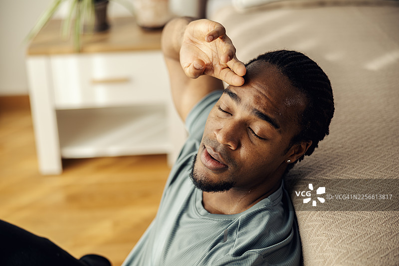 汗流浃背的男人在家锻炼后休息图片素材