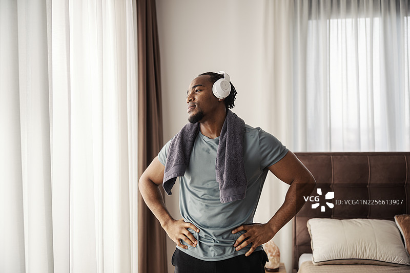 一位黑人男性在居家锻炼后戴着耳机图片素材