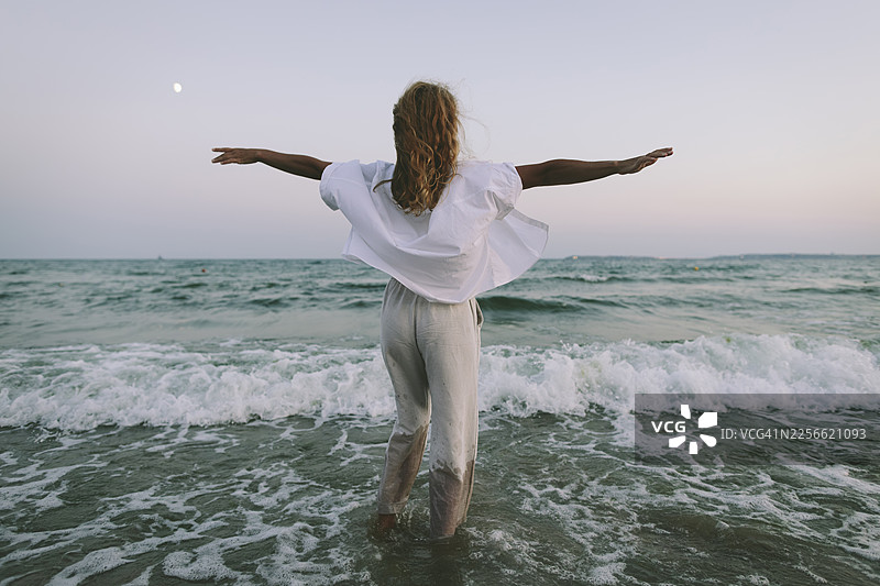 张开双臂拥抱大海，享受自由与自然的人图片素材