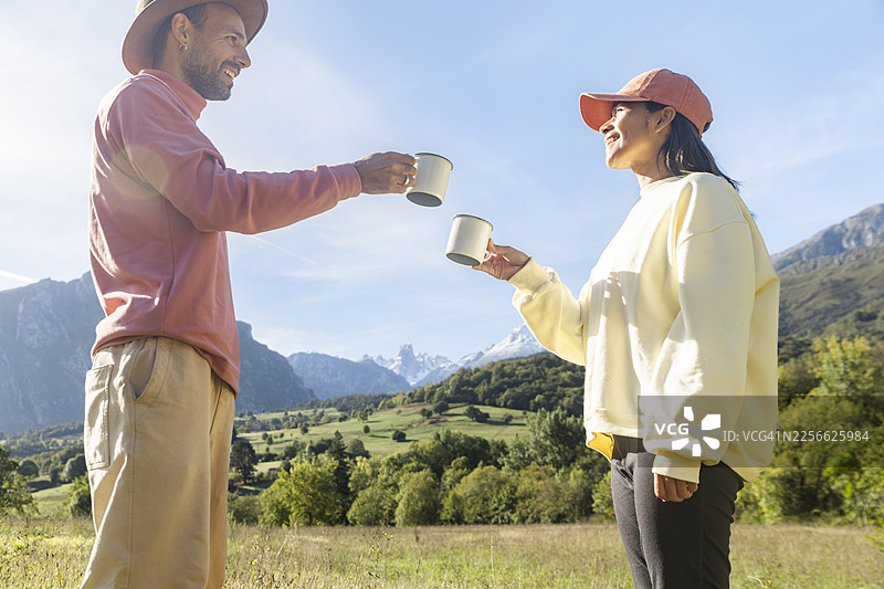 一对幸福的情侣在欧洲皮科斯国家公园户外举着马克杯，分享着玩乐的时刻图片素材