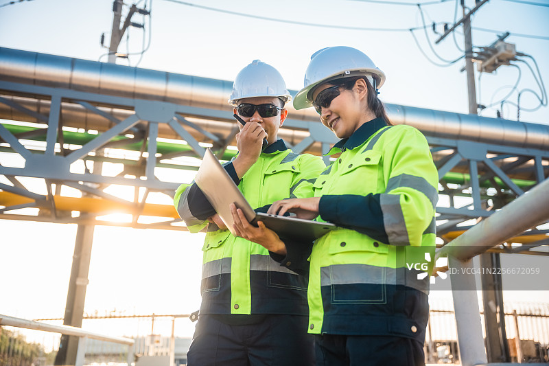 专业工程师使用数字平板电脑管理石油和天然气化石能源业务运营。图片素材
