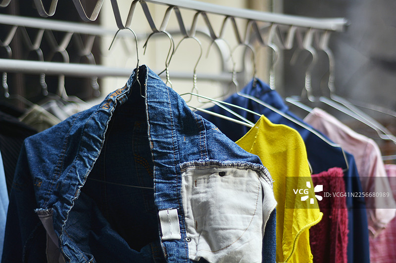 翻过来的牛仔裤和彩色衬衫挂在衣架上在户外晾干图片素材