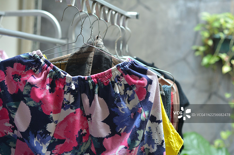 夏季户外晾衣架上悬挂的彩色碎花裤子图片素材
