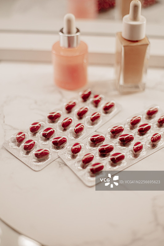 装有维生素补充剂的搅拌机，用于头发健康，包括胶原蛋白粉、生物素胶囊和天然成分。图片素材