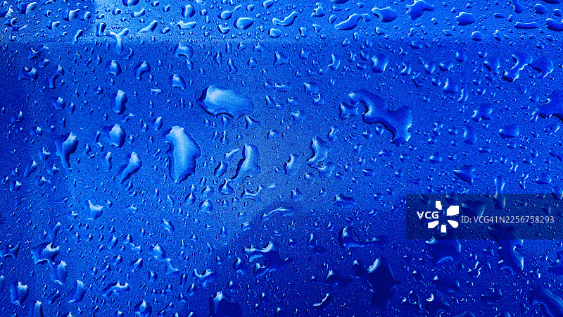 特写镜头下汽车上的水滴倒影图片素材