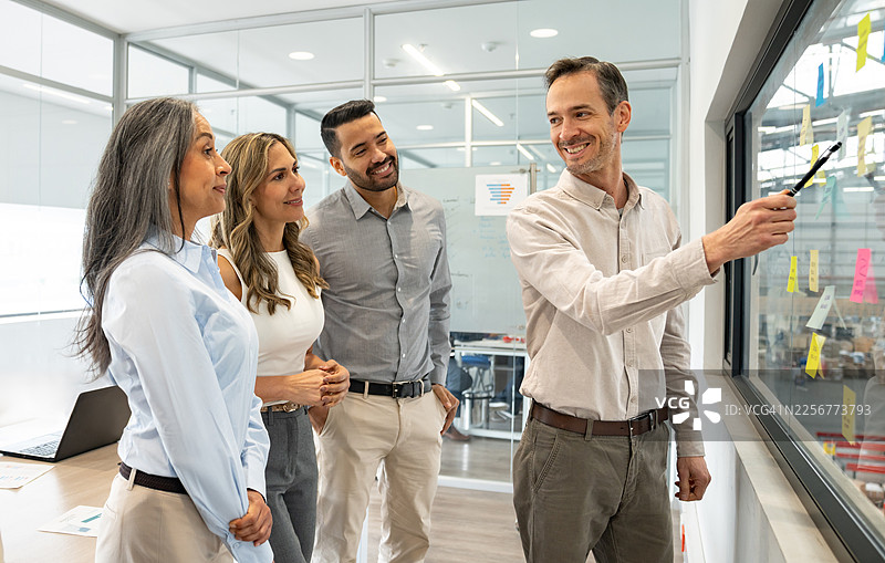 商务人士在会议上指向配送仓库的便签图片素材