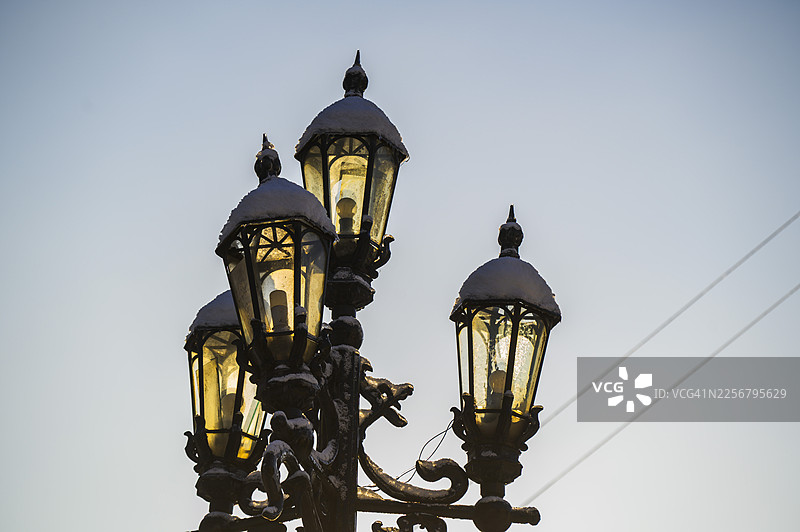 照亮冬夜雪景的复古路灯图片素材