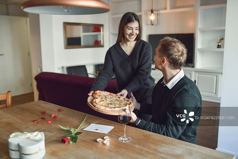 浪漫情人节居家：情侣共享披萨、美酒与玫瑰图片素材