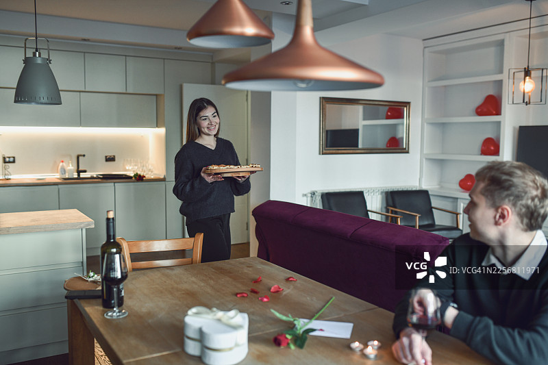 女子在情人节晚上用爱心形披萨给伴侣一个惊喜图片素材