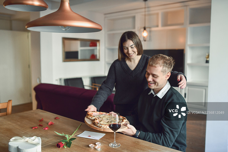 情侣享用爱心披萨和葡萄酒的休闲情人节晚餐图片素材