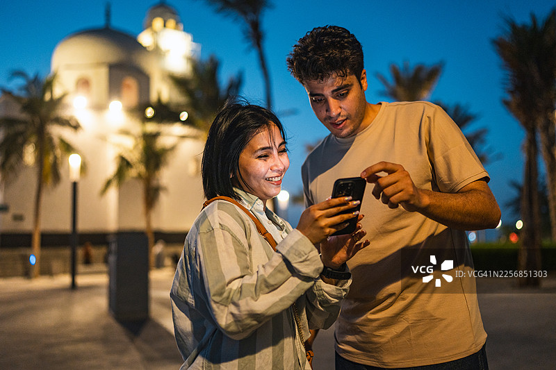 年轻多元化的游客情侣在拉赫马清真寺使用智能手机图片素材