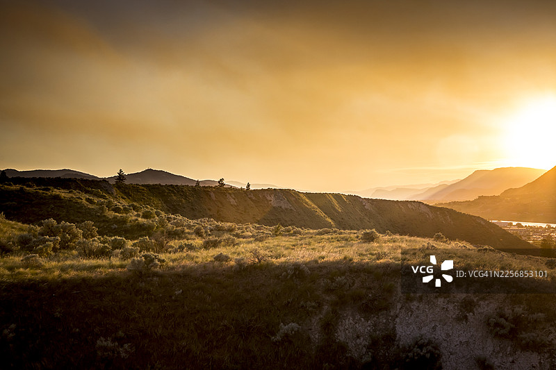 卡姆卢普斯，日落时分的群山、河流、城镇和草地图片素材