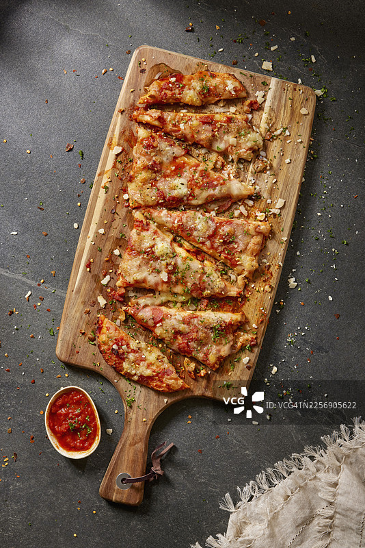 双层意大利辣香肠薄饼披萨切片放在木质砧板上图片素材