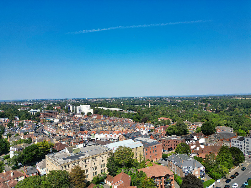 俯瞰英国伯恩茅斯马尔伯勒路城镇景色，住宅楼和茂密的绿树在晴朗的蓝天下，阳光明媚的一天图片素材