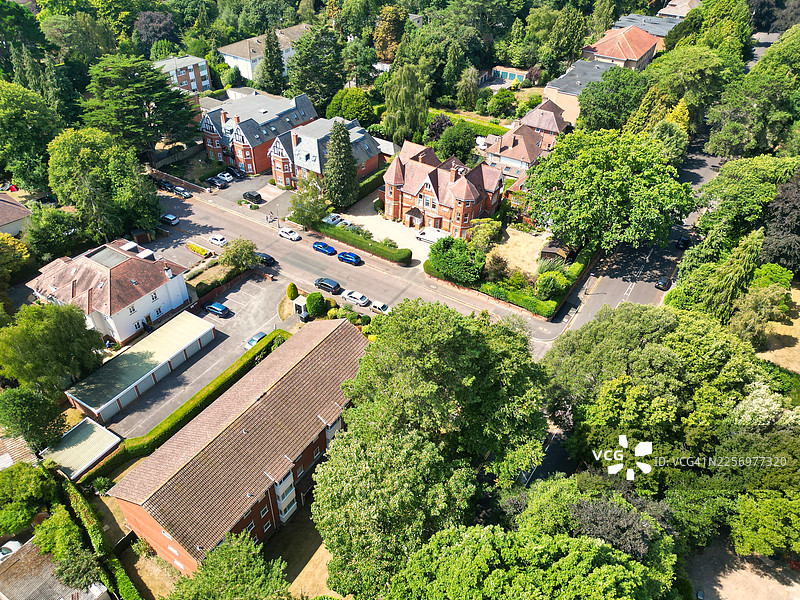 英国伯恩茅斯马尔堡路住宅区高角度空中俯瞰，阳光明媚的日子里可以看到房屋、汽车和茂密的绿树。图片素材