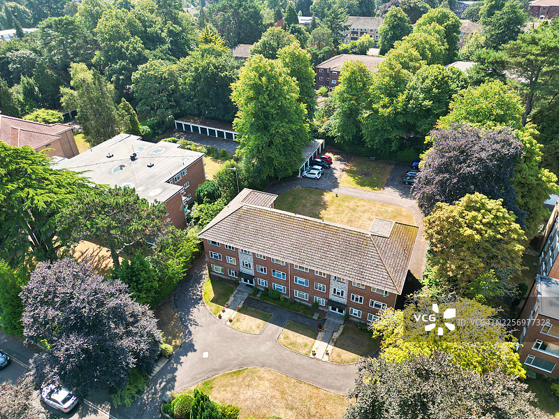 阳光明媚的日子里，英国伯恩茅斯城市中，俯瞰绿树成荫的居民楼的航拍景象图片素材