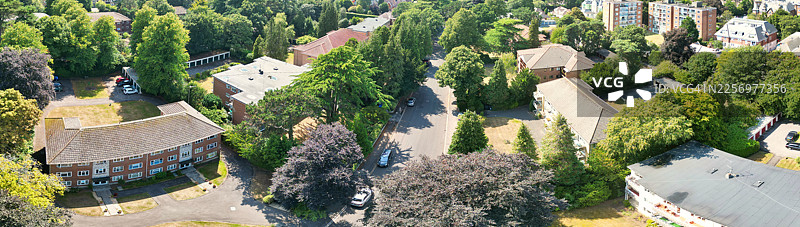 阳光明媚的日子里，英国伯恩茅斯郊区住宅楼和绿树的俯瞰航拍图图片素材