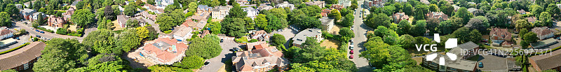阳光明媚的日子里，英国伯恩茅斯马尔伯勒路住宅区的空中全景，可以看到房屋和茂密的绿树图片素材
