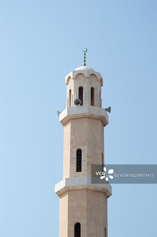 阳光明媚的日子里，清真寺的宣礼塔高耸入蓝天，象征着伊斯兰建筑和信仰，沙特阿拉伯图片素材