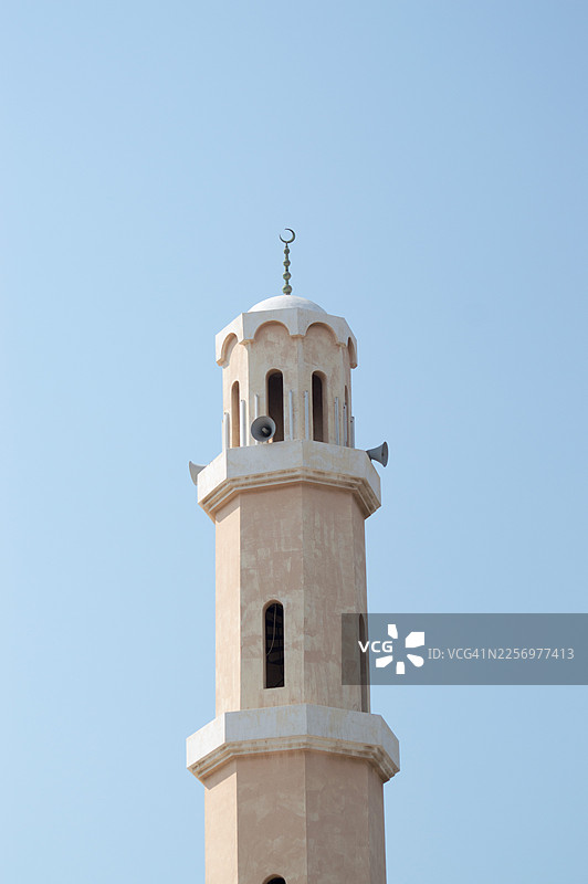 沙特阿拉伯，清澈蓝天下清真寺的宣礼塔，象征着伊斯兰文化与建筑图片素材