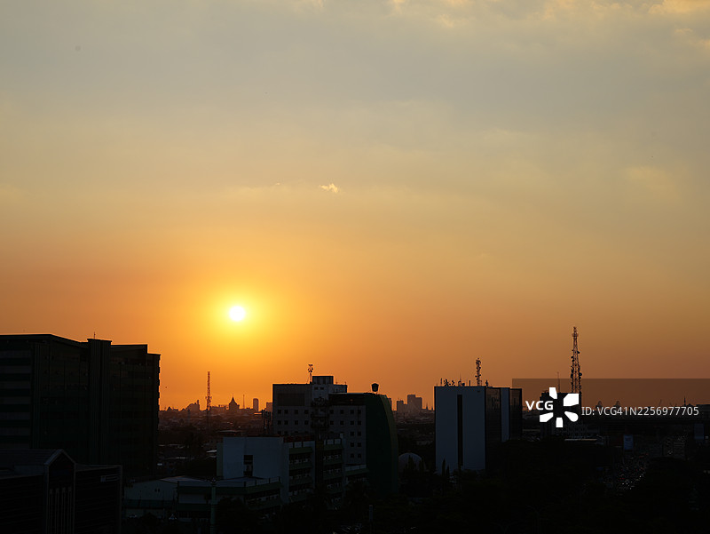 夕阳下的城市剪影，橙黄色的天空图片素材