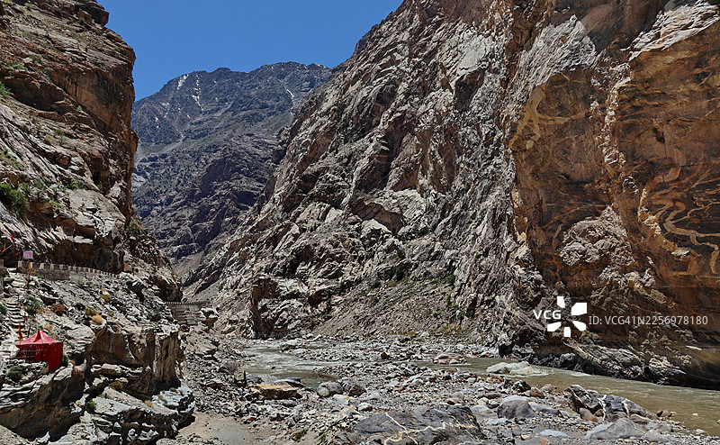 在晴朗的蓝天下，雄伟的喜马拉雅山脉与奔腾的河流交相辉映，展现着大自然的壮丽之美，印度，基诺尔凯拉萨图片素材