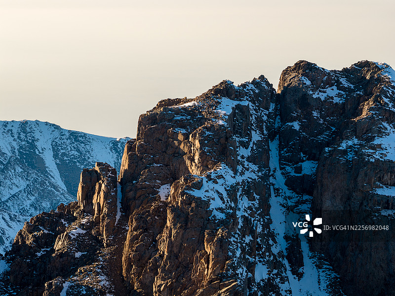 哈萨克斯坦阿拉木图，金光沐浴下的雄伟雪山，晴朗冬日的天空， यामध्येШымбулак滑雪场图片素材