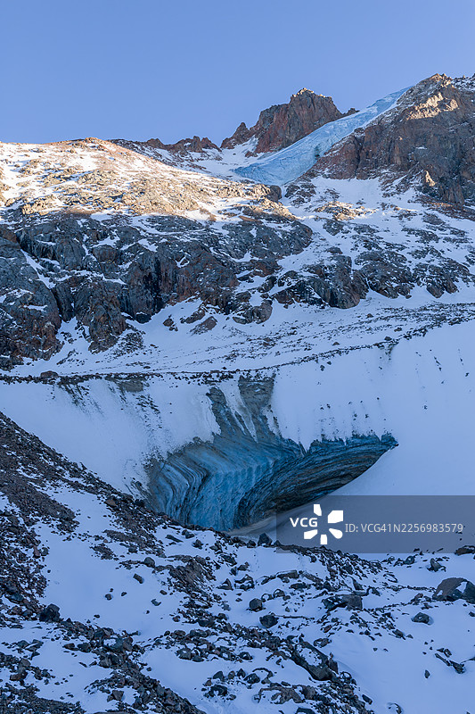 白雪皑皑的壮丽山脉和生机勃勃的蓝色冰川在晴朗的天空下，展现了冬季荒野的原始之美，哈萨克斯坦阿拉木图，金堡拉克滑雪场图片素材