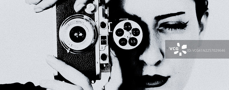 一位女士手持老式相机的黑白肖像照。图片素材