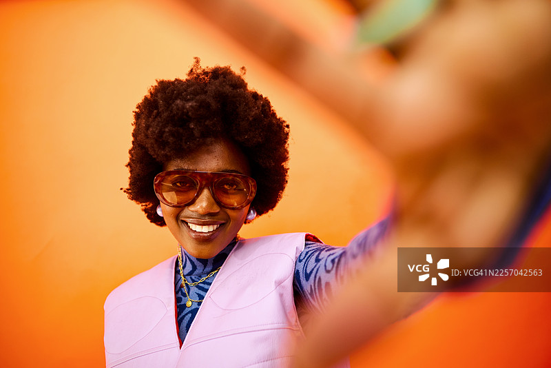 年轻的黑人女性面带微笑，正在自拍，散发着充满活力的复古风格图片素材