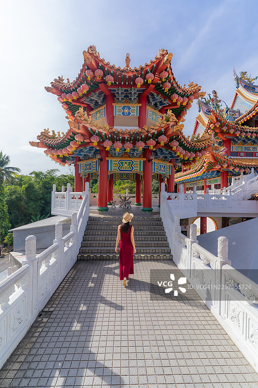 一位女性走向一座中国传统寺庙图片素材