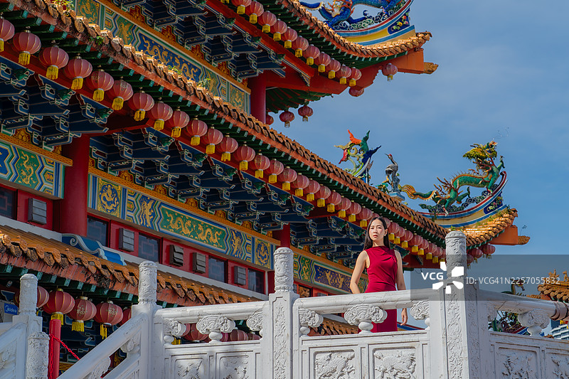 一位女子站在中国寺庙的阳台上图片素材