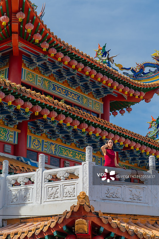 一位女士站在中国寺庙的阳台上图片素材