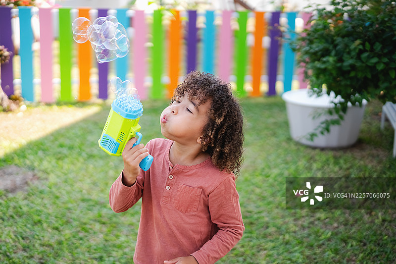 孩子在户外玩泡泡枪图片素材