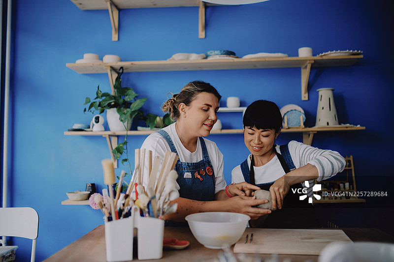 两位女士在陶艺工作室的工作台上制作陶艺图片素材