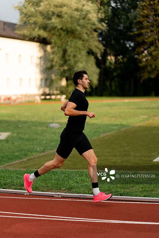 男性运动员在跑道上跑步，为比赛训练图片素材