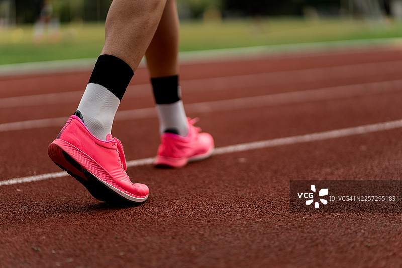 运动员的粉色跑鞋在跑道上训练图片素材